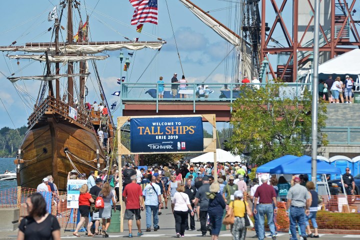 a group of people standing in front of a large ship in the background