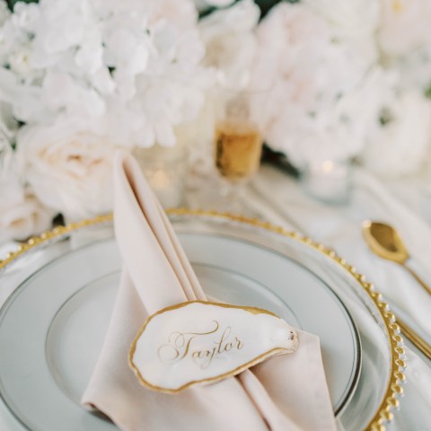 Elegant table setting with a napkin, name tag, and floral decor.