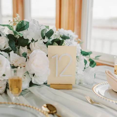 Elegant table setting with floral centerpiece and table number 12.