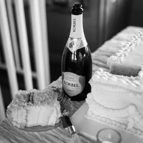 Champagne bottle with white cake slices on a decorated table.
