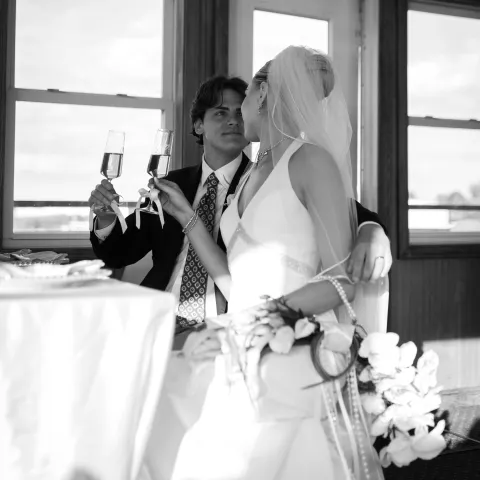 Bride and groom toasting with champagne indoors.