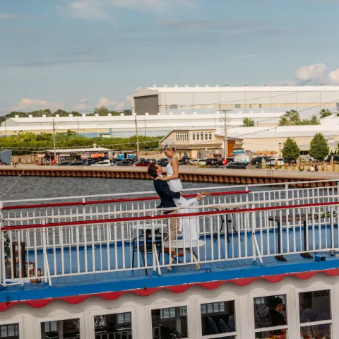 Person standing on steamboat deck posing like iconic movie scene.