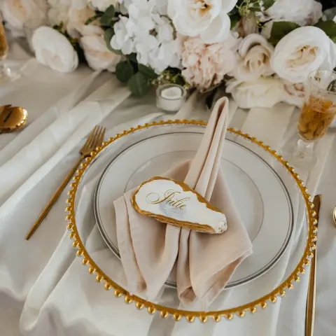 Elegant table setting with flowers and a name card on a plate.