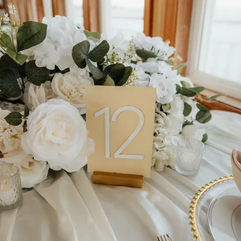 Elegant table setting with floral centerpiece and table number 12.