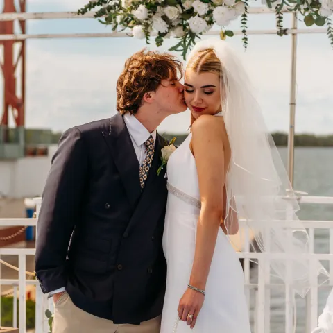 Bride and groom embracing at an outdoor wedding ceremony.